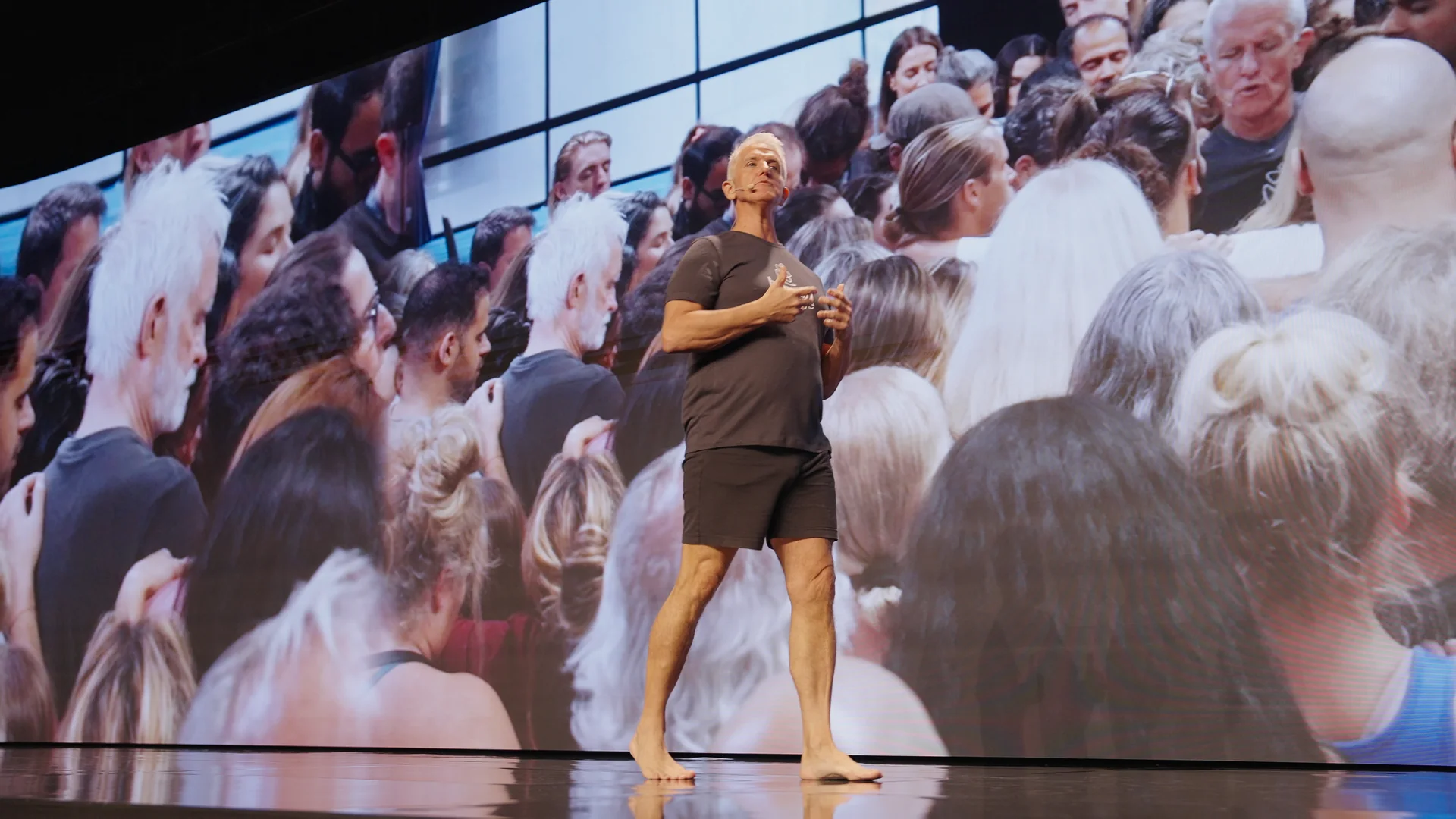Garry on stage in front of a screen filled with his audience